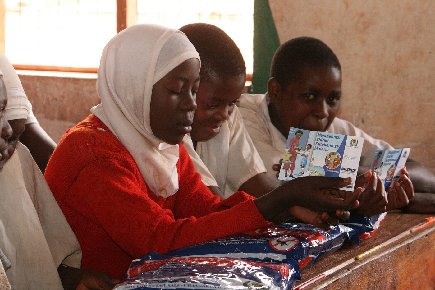Học sinh nhận màn và tờ hướng dẫn trong chương trình phát màn qua trường học ở Tanzania