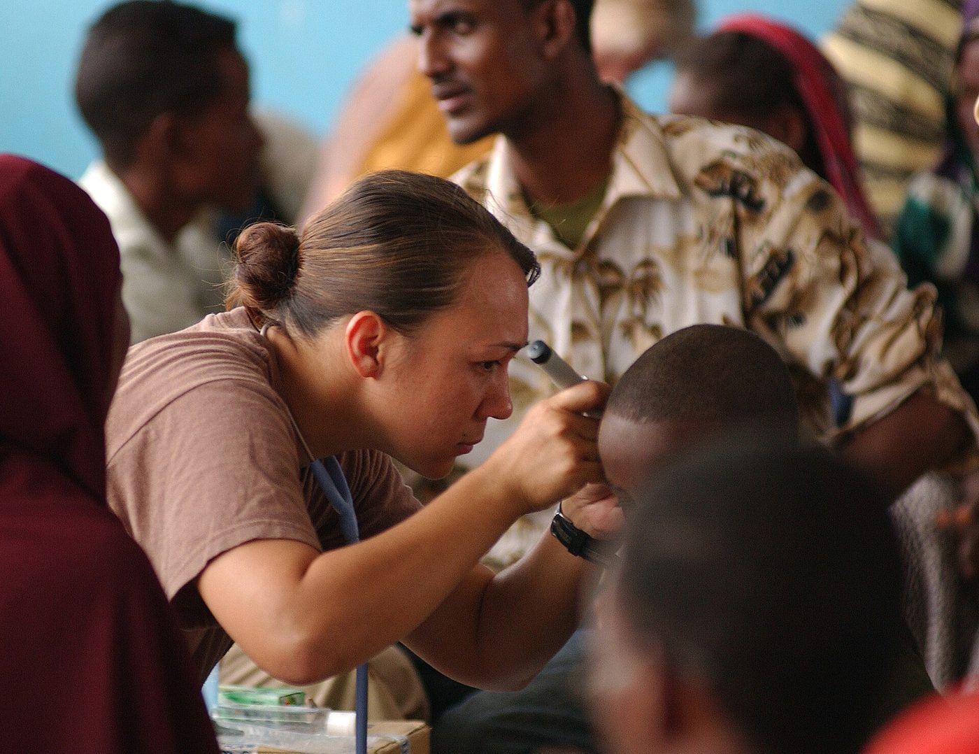 Nhân viên y tế soi tai cho một em nhỏ bằng đèn soi tai (Gode, Ethiopia, 2005)